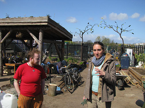eastside-jenny-w-living-roof-and-sculpture_8335 Jenny and one of the volunteers, sculpture gate and living roof on shelter behind.