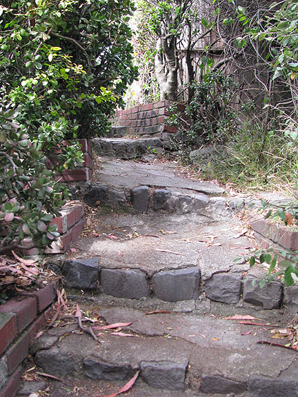 kansas-stairway-brick_0431 As you climb the stairs become more regular, and at the top you ascend a cement flight and emerge from behind a fence. This path is well hidden!