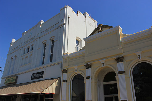 Wheatland's Grange Hall (and Odd Fellows Building) with the yellow building sporting some ornate decorations, all wheat-inspired.