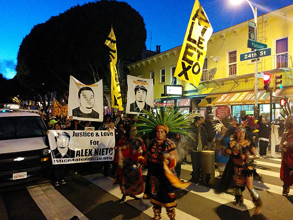 Marchers pause at 24th and Folsom during the longest night of the year, celebrating a Posada for Alex Nieto.